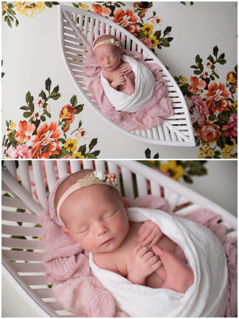 newborn baby girl swaddled in white basket with flowers