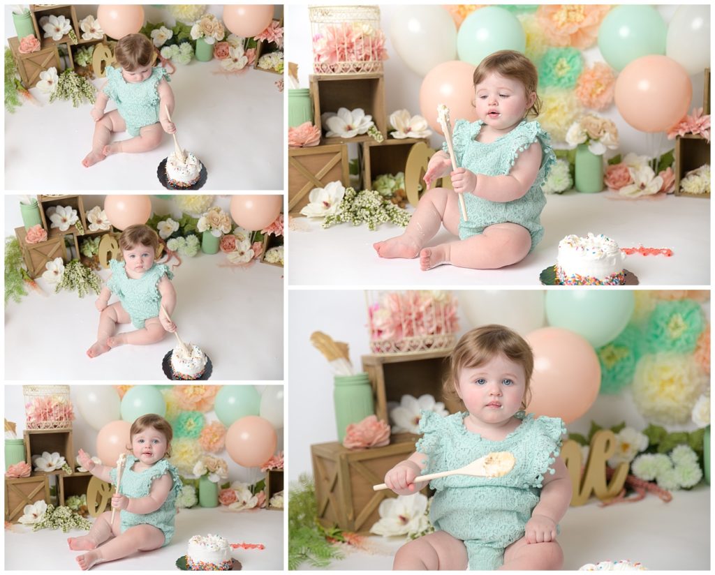 first birthday photography cake smash with baby girl holding wooden spoon with peach and mint decorations