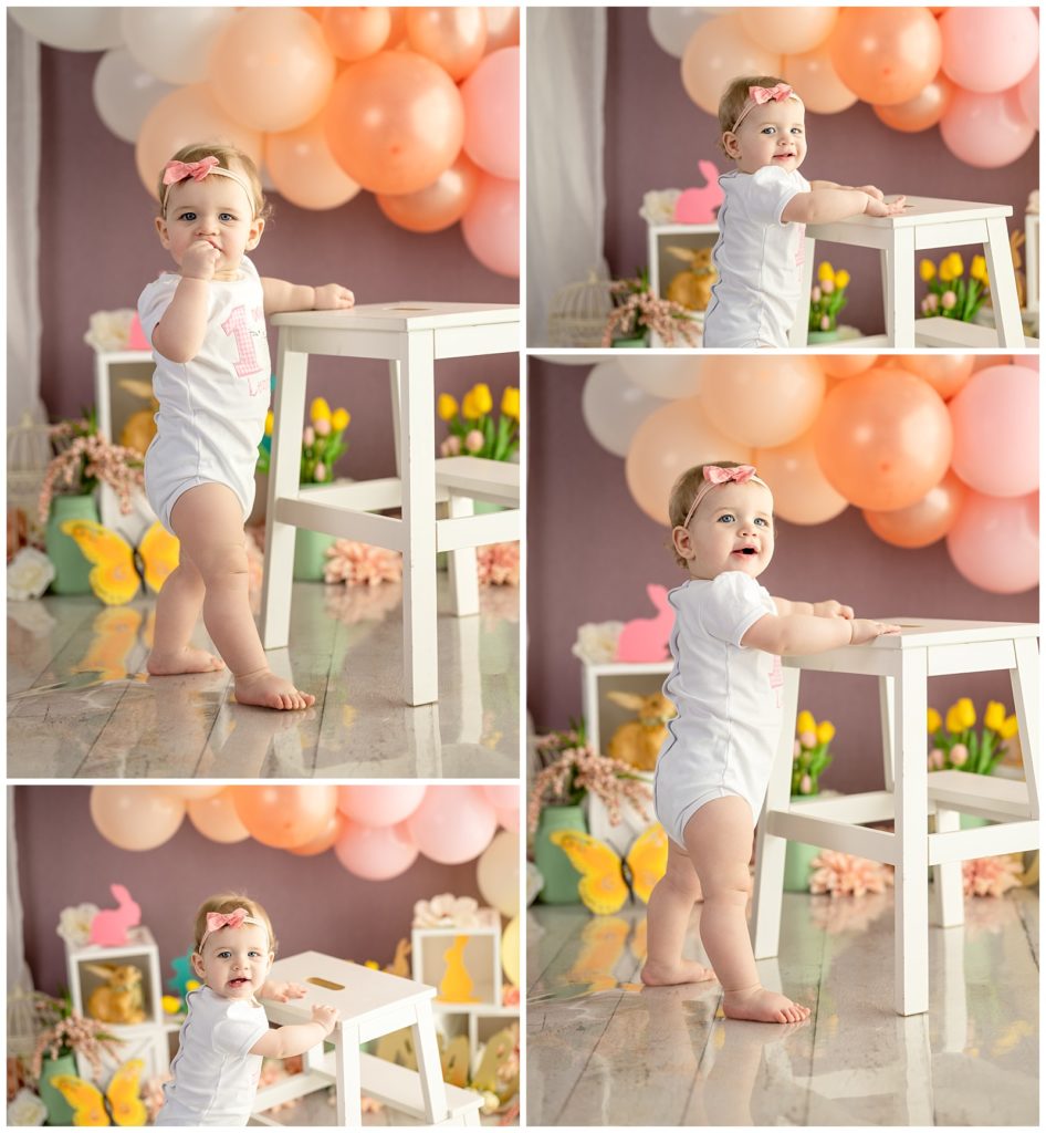 one year old girl standing with stool 