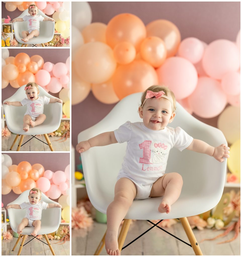 baby girl first birthday in white chair with balloons