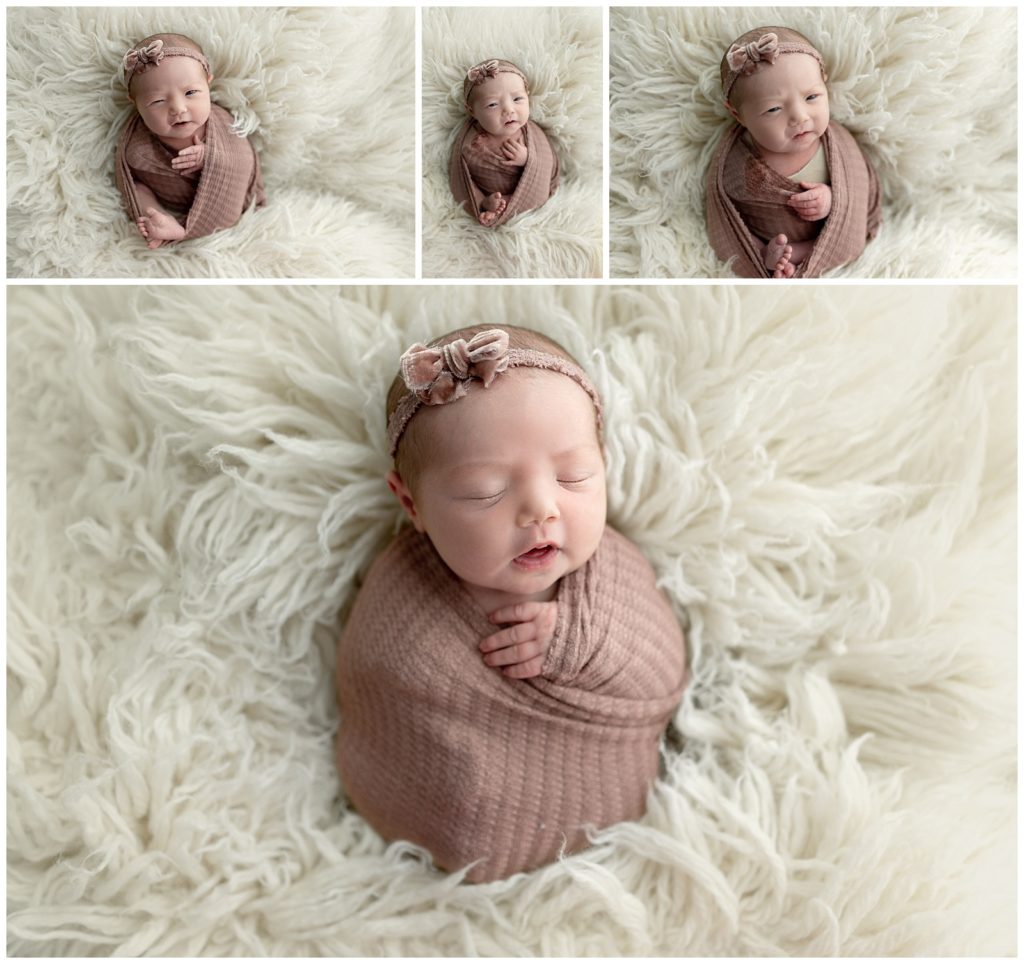 newborn baby girl on white flokati with a purple swaddled
