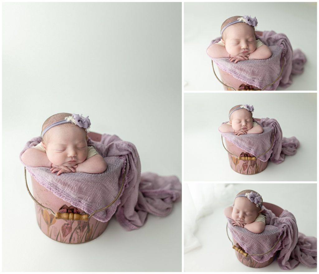 newborn baby girl in a bucket with purples